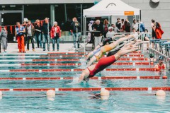 Erster Freibad-Wettkampf der Saison. Im Hintergrund in der Jacke, müssen die SchwimmerInnen auf der 50 Meter Bahn ihre Leistungen zeigen. Foto: Wolfgang Schlabschi